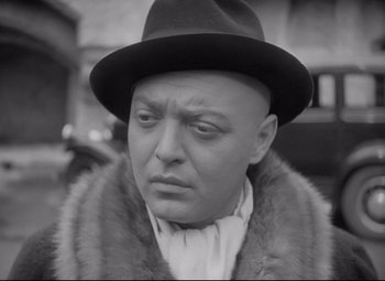 Movie still from “Mad Love” (1935), directed by Karl Freund – A man wearing a fur coat and a hat; Close Up shot, High angle