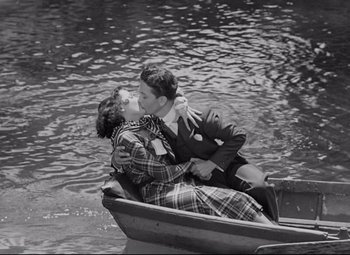 Movie still from “Mad Love” (1935), directed by Karl Freund – A man and a woman kissing in a small boat; Wide shot, High angle