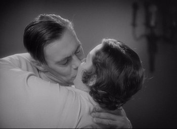 Movie still from “Mad Love” (1935), directed by Karl Freund – A man and a woman are kissing in a room; Medium shot, High angle