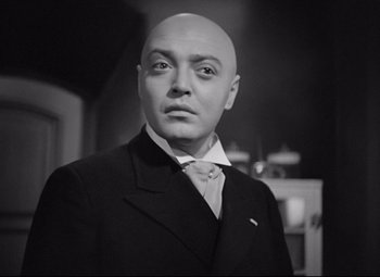 Movie still from “Mad Love” (1935), directed by Karl Freund – A black and white photo of a man in a suit and tie; Close Up shot, Low angle