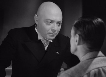 Movie still from “Mad Love” (1935), directed by Karl Freund – A man in a suit talking to another man in a suit; Close Up shot, Over the shoulder angle