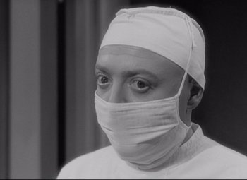Movie still from “Mad Love” (1935), directed by Karl Freund – A man wearing a surgical mask and a white surgical cap; Close Up shot, High angle