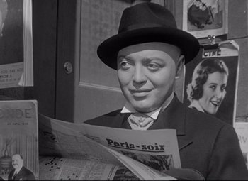 Movie still from “Mad Love” (1935), directed by Karl Freund – A black and white photo of a man reading a newspaper; Close Up shot, Over the shoulder angle