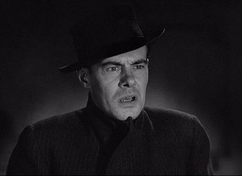 Movie still from “Mad Love” (1935), directed by Karl Freund – A man wearing a black hat and a black jacket; Close Up shot, Low angle