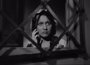 Movie still from “Mad Love” (1935), directed by Karl Freund – A woman is talking on a cell phone through a fence; Close Up shot, High angle