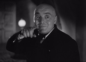 Movie still from “Mad Love” (1935), directed by Karl Freund – A man with bald head is pointing to his face; Close Up shot, Low angle