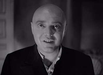Movie still from “Mad Love” (1935), directed by Karl Freund – A man with a bald head wearing a suit and tie; Close Up shot, Low angle