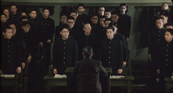 Movie still from “Madadayo” (1993), directed by Akira Kurosawa – A group of men standing in front of a man in a suit; Wide shot, High angle