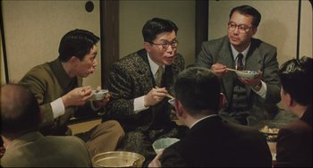 Movie still from “Madadayo” (1993), directed by Akira Kurosawa – A group of men sitting around a table eating food; Medium shot, High angle