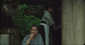 Movie still from “Madadayo” (1993), directed by Akira Kurosawa – An older man sitting in front of a woman; Medium shot, Low angle