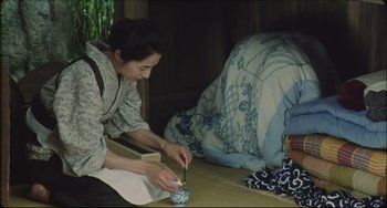 Movie still from “Madadayo” (1993), directed by Akira Kurosawa – A woman sitting on the floor with a cup of tea; Wide shot, High angle