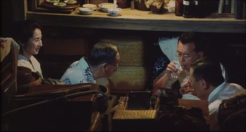 Movie still from “Madadayo” (1993), directed by Akira Kurosawa – Two men sitting at a table drinking from glasses; Medium shot, High angle