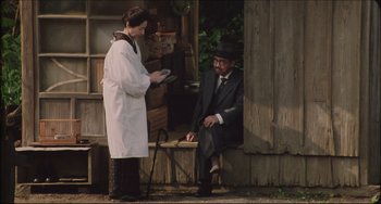 Movie still from “Madadayo” (1993), directed by Akira Kurosawa – An older man sitting on a bench next to an older woman; Wide shot, High angle