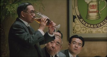 Movie still from “Madadayo” (1993), directed by Akira Kurosawa – A group of men sitting in front of each other drinking; Medium shot, Low angle