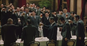 Movie still from “Madadayo” (1993), directed by Akira Kurosawa – A group of men toasting with beer at a table; Wide shot, High angle