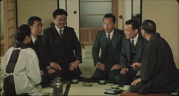 Movie still from “Madadayo” (1993), directed by Akira Kurosawa – A group of men in suits sitting around a table; Medium shot, High angle