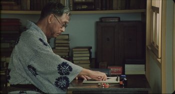 Movie still from “Madadayo” (1993), directed by Akira Kurosawa – An older man is sitting at a table; Medium shot, Low angle