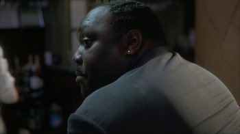 Movie still from “Made” (2001), directed by Jon Favreau – A person wearing a suit and ear cuff; Close Up shot, Over the shoulder angle