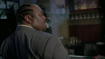 Movie still from “Made” (2001), directed by Jon Favreau – A man in a suit smoking a cigarette in front of a bar; Close Up shot, Low angle