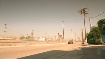 Movie still from “Made” (2001), directed by Jon Favreau – A car driving down a street near power lines; Extreme Wide shot, High angle