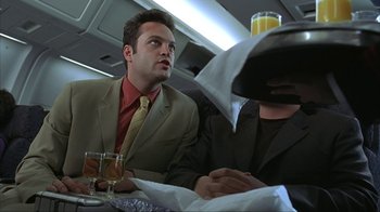 Movie still from “Made” (2001), directed by Jon Favreau – A man sitting at a table with a glass of orange juice; Medium shot, Low angle