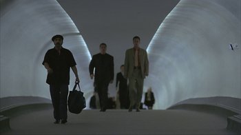 Movie still from “Made” (2001), directed by Jon Favreau – A group of men walking down a hallway with bags; Wide shot, Low angle