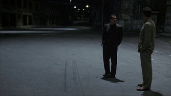 Movie still from “Made” (2001), directed by Jon Favreau – A man standing in the middle of an empty parking lot at night; Wide shot, High angle