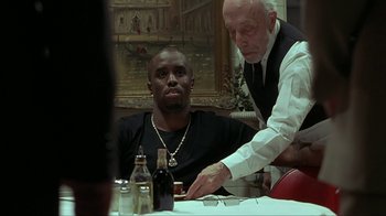 Movie still from “Made” (2001), directed by Jon Favreau – A man sitting at a table in front of another man; Medium shot, Over the shoulder angle