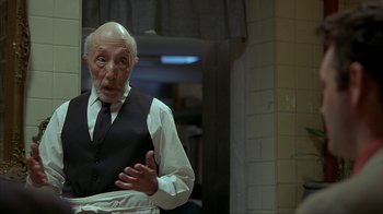 Movie still from “Made” (2001), directed by Jon Favreau – An old man wearing a vest and a tie; Medium shot, Low angle