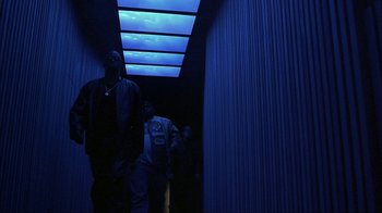 Movie still from “Made” (2001), directed by Jon Favreau – Two men walking down a hallway in the dark; Medium shot, Low angle