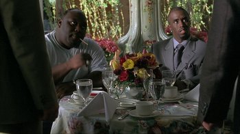 Movie still from “Made” (2001), directed by Jon Favreau – A couple of men sitting at a dinner table; Medium shot, Over the shoulder angle