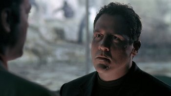 Movie still from “Made” (2001), directed by Jon Favreau – A person wearing a suit and smoking a cigarette; Close Up shot, Low angle