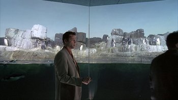 Movie still from “Made” (2001), directed by Jon Favreau – A man standing in front of an image of rocks; Medium shot, Over the shoulder angle