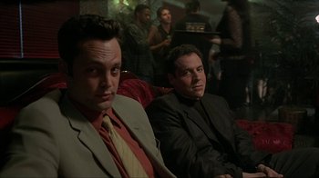 Movie still from “Made” (2001), directed by Jon Favreau – A couple of men sitting next to each other in a room; Medium shot, High angle