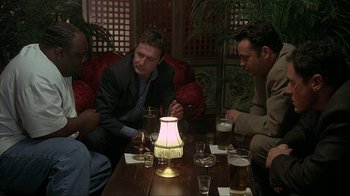 Movie still from “Made” (2001), directed by Jon Favreau – A group of men sitting around a table with drinks; Medium shot, High angle