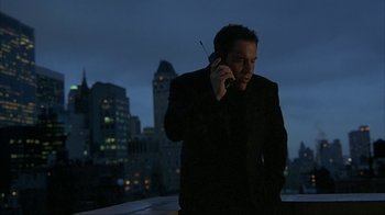 Movie still from “Made” (2001), directed by Jon Favreau – A man in a black suit talking on a cell phone; Medium shot, Low angle