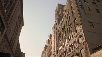 Movie still from “Made” (2001), directed by Jon Favreau – A view of a tall brick building from the street; Extreme Wide shot, Low angle