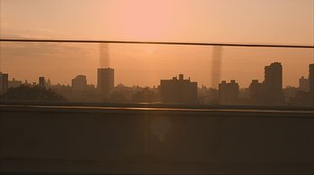 Movie still from “Made” (2001), directed by Jon Favreau – The sun is setting over a city skyline; Extreme Wide shot, Low angle
