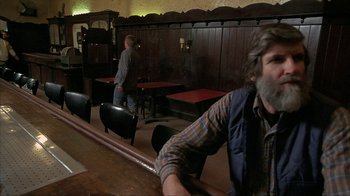 Movie still from “Made” (2001), directed by Jon Favreau – A man sitting at a table in front of a wall; Medium shot, Over the shoulder angle