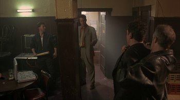 Movie still from “Made” (2001), directed by Jon Favreau – A group of men standing in a room; Medium shot, Over the shoulder angle