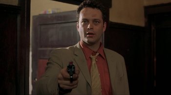 Movie still from “Made” (2001), directed by Jon Favreau – A man in a suit and tie holding a gun; Close Up shot, Low angle