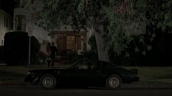 Movie still from “Made” (2001), directed by Jon Favreau – A man walking down a street next to a car; Wide shot, Low angle