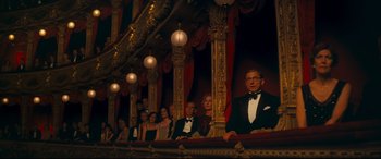 Movie still from “Magic in the Moonlight” (2014), directed by Woody Allen – A group of people sitting on a stage in front of a curtain; Wide shot, Low angle