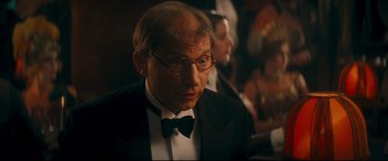 Movie still from “Magic in the Moonlight” (2014), directed by Woody Allen – A man in a suit and bow tie looking to his left; Close Up shot, Over the shoulder angle