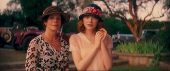 Movie still from “Magic in the Moonlight” (2014), directed by Woody Allen – A woman and a girl wearing hats posing for a picture; Medium shot, Over the shoulder angle