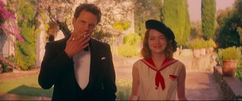Movie still from “Magic in the Moonlight” (2014), directed by Woody Allen – A man and a woman standing next to each other in front of trees; Medium shot, Over the shoulder angle