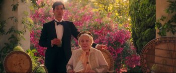 Movie still from “Magic in the Moonlight” (2014), directed by Woody Allen – An older woman sitting in a chair next to a young man; Medium shot, Low angle