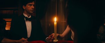 Movie still from “Magic in the Moonlight” (2014), directed by Woody Allen – A man and a woman are holding a lit candle; Medium shot, Over the shoulder angle