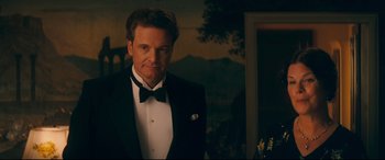 Movie still from “Magic in the Moonlight” (2014), directed by Woody Allen – A man in a tuxedo standing in front of a painting; Medium shot, Low angle