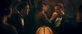 Movie still from “Magic in the Moonlight” (2014), directed by Woody Allen – A group of people sitting in a room talking to each other; Medium shot, Over the shoulder angle
